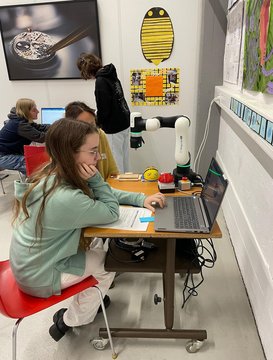 La ragazza si concentra sul lavoro al computer con il braccio robotico
