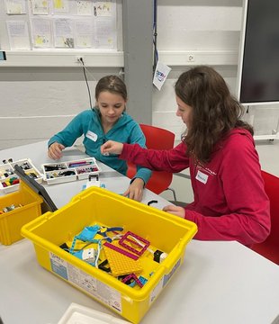 Due ragazze costruiscono con i LEGO in un'aula scolastica