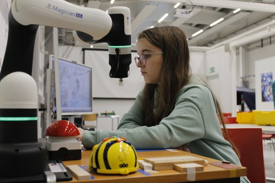 Una ragazza testa la tecnologia con un assistente robot