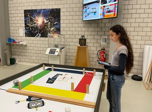 Ragazza con tablet accanto a un campo da gioco colorato